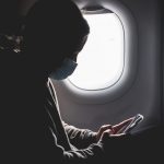 woman in black long sleeve shirt sitting on airplane seat