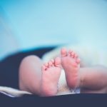shallow focus photography of baby wearing white diaper lying