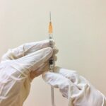 person in white long sleeve shirt holding silver and black tube type mod