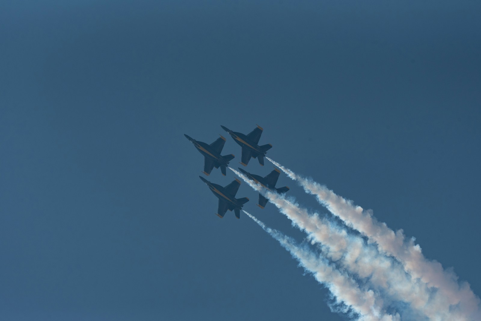 a group of fighter jets flying through a blue sky