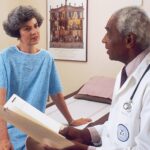 man in blue crew neck t-shirt holding white printer paper