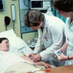 a woman laying in a hospital bed next to a man